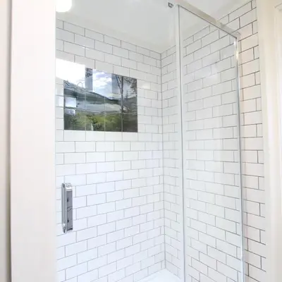 a white tiled shower with a glass door at Fiber Artist's Studio in Woodstock