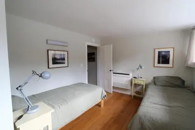 a bedroom with two beds and a desk with a lamp at Fiber Artist's Studio in Woodstock