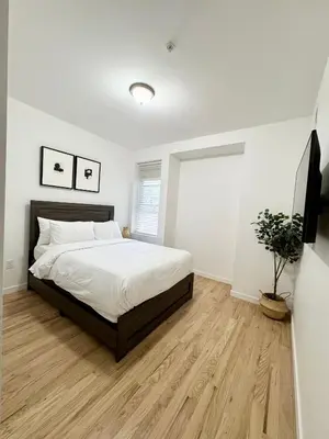 a bedroom with a bed and a wooden floor at The Signature Modern Flat in Newark