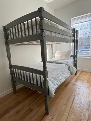 a bunk bed in a room with a wooden floor at The Signature Modern Flat in Newark