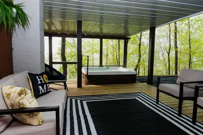 a living room with a tub on a deck at NEW! Montview Chalet - Hot Tub, Sauna, EV, Views in East Stroudsburg