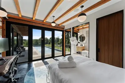 a bedroom with a large bed and a desk and windows at Hudson Ridge - Hot Tub, Fire Pit & Fireplace in Hudson