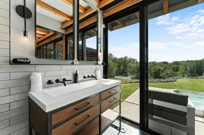 a bathroom with a sink and a tub and a window at Hudson Ridge - Hot Tub, Fire Pit & Fireplace in Hudson
