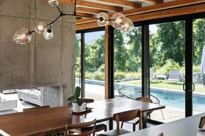 a dining room with a table and a view of a pool at Hudson Ridge - Hot Tub, Fire Pit & Fireplace in Hudson