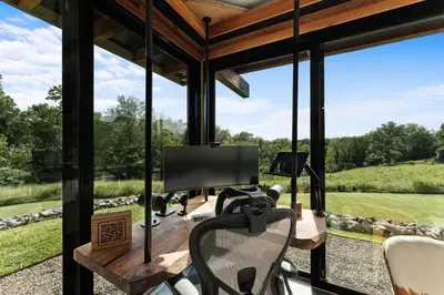 an office with a view of the golf course through the glass windows at Hudson Ridge - Hot Tub, Fire Pit & Fireplace in Hudson