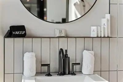 a bathroom with a sink with a mirror and towels at Hudson Ridge - Hot Tub, Fire Pit & Fireplace in Hudson