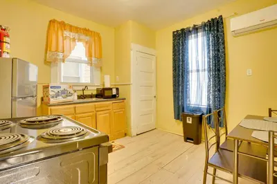 a kitchen with yellow walls and a stove top oven at Easy City Commuting! Walkable Newark Duplex in Newark