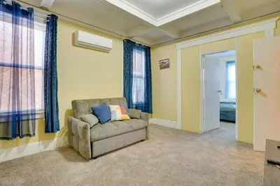 a living room with a chair and a window at Easy City Commuting! Walkable Newark Duplex in Newark