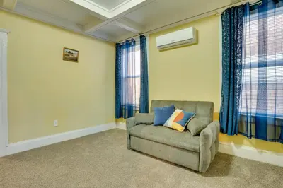 a living room with a chair and windows at Easy City Commuting! Walkable Newark Duplex in Newark