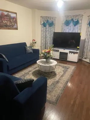 a living room with blue couches and a tv at Enjoyable 3-bedroom house in charming East Orange neighborhood in East Orange