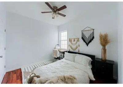 a bedroom with a bed and a ceiling fan at Secür Your Vacation Home in Jersey City