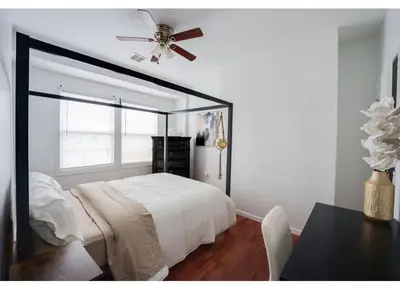 a bedroom with a bed and a ceiling fan at Secür Your Vacation Home in Jersey City