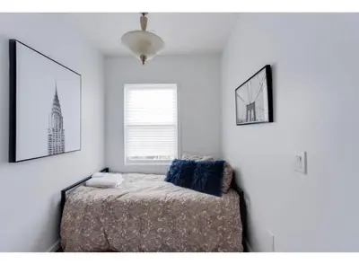 a bedroom with a bed and a window at Secür Your Vacation Home in Jersey City