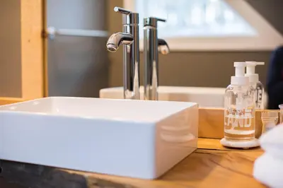 a white bathroom sink with a faucet on a counter at Rustic Luxe Creekside Retreat with Hot Tub and Fire Pit, Minutes From Hudson in Hudson
