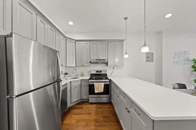 a kitchen with white cabinets and a stainless steel refrigerator at Park Hamilton House 3B2B Modern Apt Mins to NYC in Jersey City