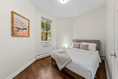 a white bedroom with a bed and a window at Park Hamilton House 3B2B Modern Apt Mins to NYC in Jersey City