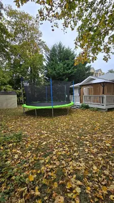 a seesaw in a yard with leaves on the ground at Family-Friendly Retreat With Trampoline & Grill in Locust Valley