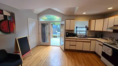 a kitchen with an open door to a yard at Family-Friendly Retreat With Trampoline & Grill in Locust Valley