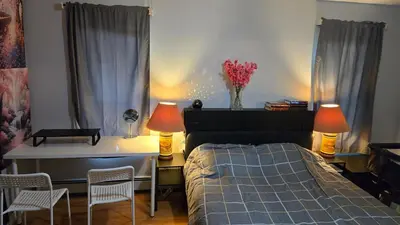 a bedroom with a bed and a desk and two lamps at Family-Friendly Retreat With Trampoline & Grill in Locust Valley