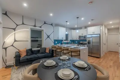 a kitchen and living room with a table and chairs at Pristine Pad, Sleep 12, Free parking, 3BRs, 20 PERCENT OFF in East Newark
