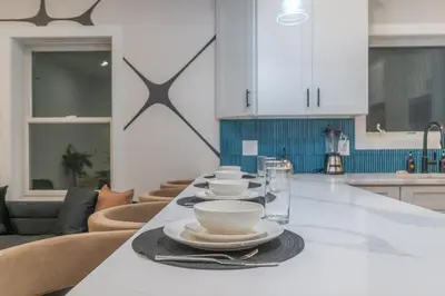 a kitchen with a table with plates and bowls on it at Pristine Pad, Sleep 12, Free parking, 3BRs, 20 PERCENT OFF in East Newark