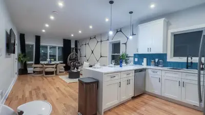 a large kitchen with white cabinets and blue tiles at Pristine Pad, Sleep 9, Free driveway park, 20 PERCENT OFF in East Newark