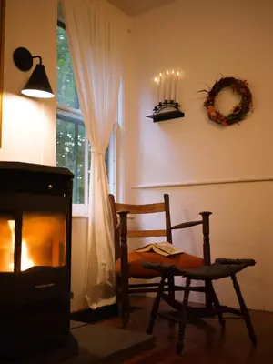 a living room with a chair and a fireplace at The Swiss Hill Farmhouse - 5 Bedrooms w Hot Tub in Jeffersonville