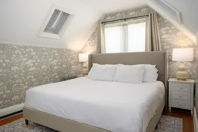 a bedroom with a white bed and a window at The Berkshire Mountain Inn in Great Barrington