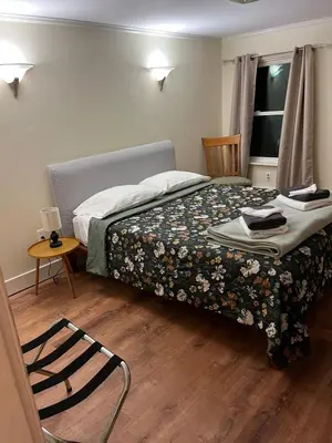 a bedroom with a bed and a chair and a window at Cozy Stay Near Jiminy Peak & Bousquet Mountain in New Lebanon