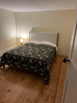 a bedroom with a bed with a flowered comforter at Cozy Stay Near Jiminy Peak & Bousquet Mountain in New Lebanon