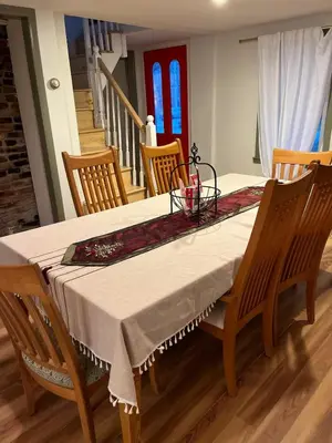 a dining room table with a white table cloth and chairs at Cozy Stay Near Jiminy Peak & Bousquet Mountain in New Lebanon