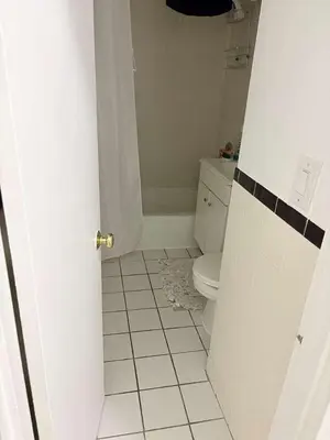a bathroom with a toilet and a tiled floor at Beautiful cozy place in HEART MANHATTAN in New York