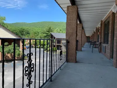 a porch with a wrought iron fence and a building at West Point Motel in Highland Falls