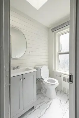 a white bathroom with a toilet and a sink at Modern Loft Apartments, Stylish Design Near Midtown in New York