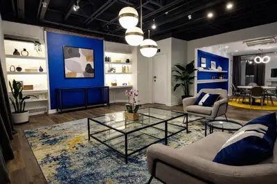 a living room with blue walls and a glass table at Modern Loft Apartments, Stylish Design Near Midtown in New York