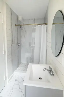 a white bathroom with a sink and a mirror at Modern Loft Apartments, Stylish Design Near Midtown in New York