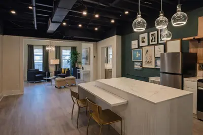 a kitchen and living room with a counter and chairs at Modern Loft Apartments, Stylish Design Near Midtown in New York