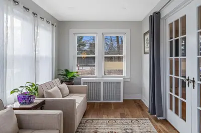 a living room with a couch and two windows at 5BR Home Minutes to NYC and FIFA 2026 Sleeps 16 in Teaneck