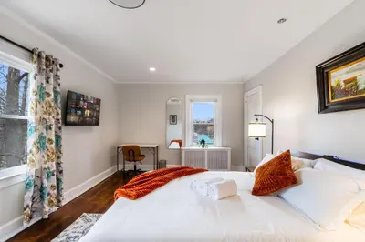 a bedroom with a large white bed and a window at 5BR Home Minutes to NYC and FIFA 2026 Sleeps 16 in Teaneck