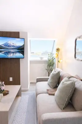 a living room with a couch and a tv on a wall at Yale Getaway Parking Wooster Square King Bed in New Haven