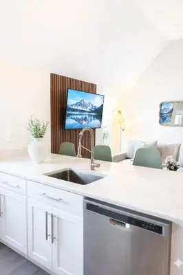 a kitchen with a sink and a tv on the wall at Yale Getaway Parking Wooster Square King Bed in New Haven