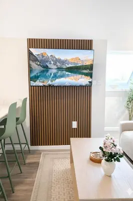 a living room with a tv on a wall at Yale Getaway Parking Wooster Square King Bed in New Haven