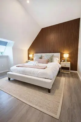 a bedroom with a large bed with a wooden wall at Yale Getaway Parking Wooster Square King Bed in New Haven