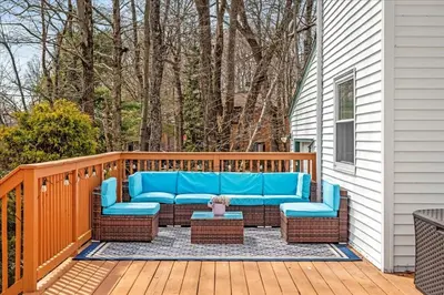 a porch with a blue couch on a wooden deck at Cozy Pocono Retreat in Tobyhanna