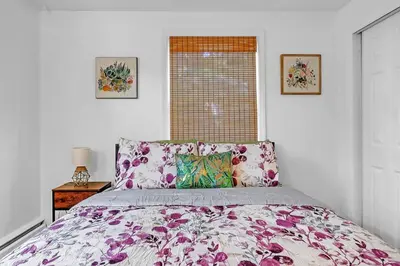 a bedroom with a bed with a floral bedspread and a window at 4 Bedroom House Near Bristol Center in Bristol