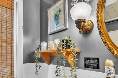a mirror hanging on a wall next to a shelf at 4 Bedroom House Near Bristol Center in Bristol