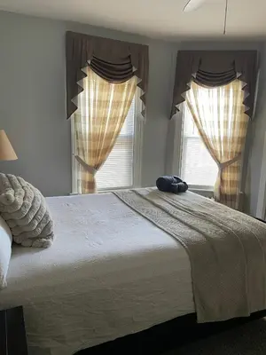 a bedroom with a large bed with two windows at PRIVATE ROOM IN SHARED 3 BED - 1 BATH home in Hartford