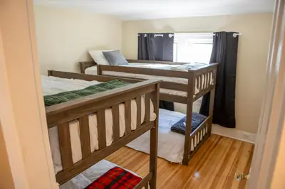 a room with three bunk beds and a doorway at Ann Inn - Downtown New Milford Apartment in New Milford