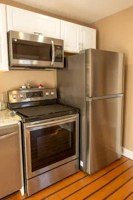 a kitchen with a stainless steel refrigerator and a microwave at Ann Inn - Downtown New Milford Apartment in New Milford