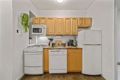 a kitchen with white appliances and wooden cabinets at Suite Double Room with shared bathroom in Times Square in New York